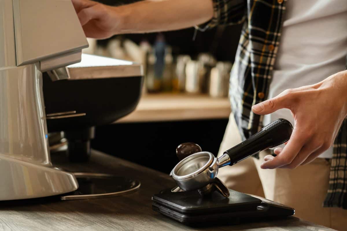 特写镜头的咖啡研磨咖啡。专业的咖啡师的工作添麻烦咖啡咖啡机。热倒饮料的概念。健美的图片