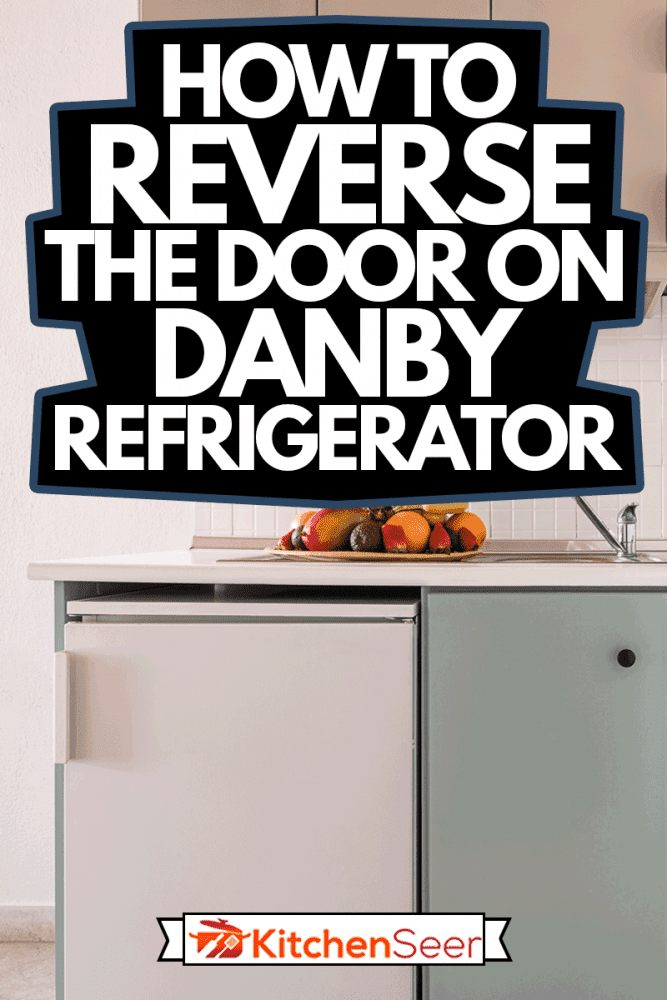 特写镜头的白色瓷砖防溅挡板在空墙简单的内阁模块的现代室内厨房用小冰箱,发泄,水槽,火炉,水果盘,如何逆转丹比冰箱的门雷电竞官网网址