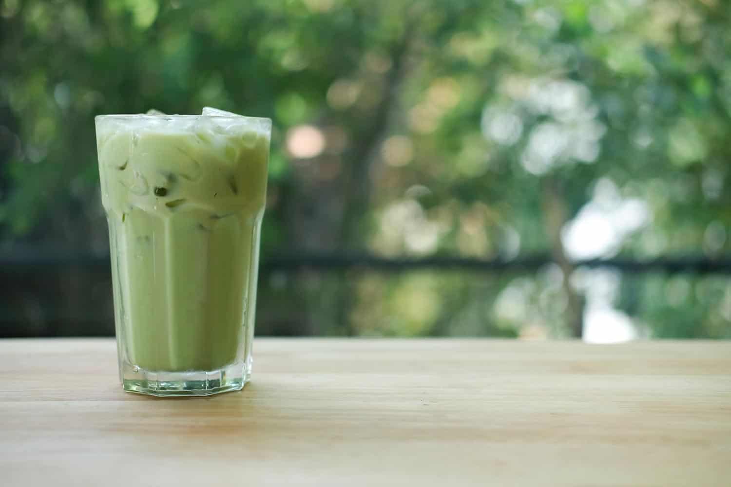 冰绿茶在玻璃与冰在咖啡店的表”width=