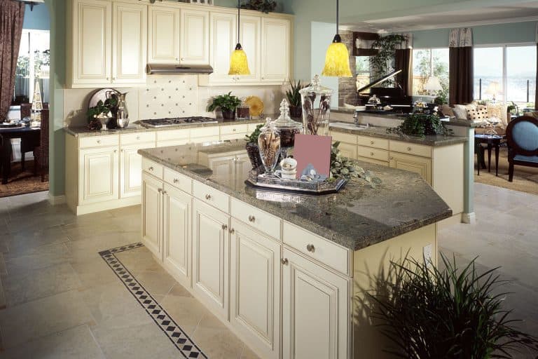 Elegant classic inspired kitchen with cream painted cupboards and cabinets with a brown granite countertop, What Color Walls Go With Brown Granite Countertops?