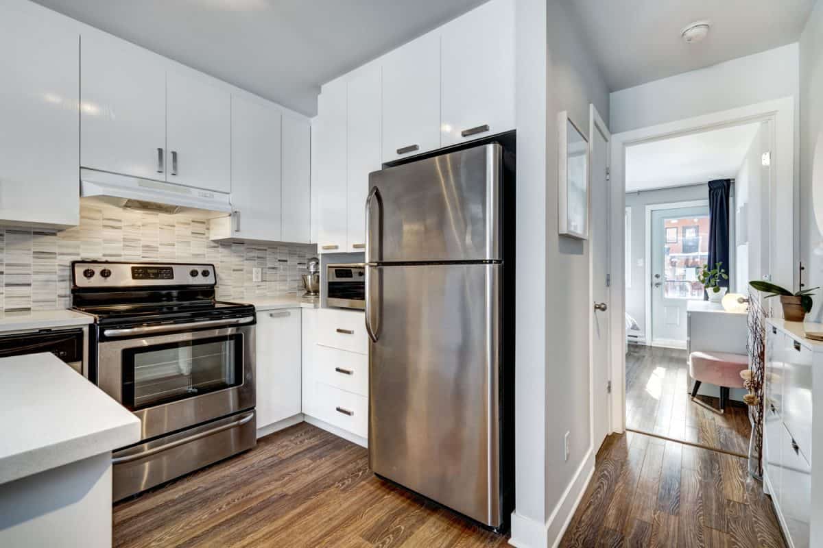 狭窄的木制地板的公寓房间,白色的橱柜和白色的橱柜