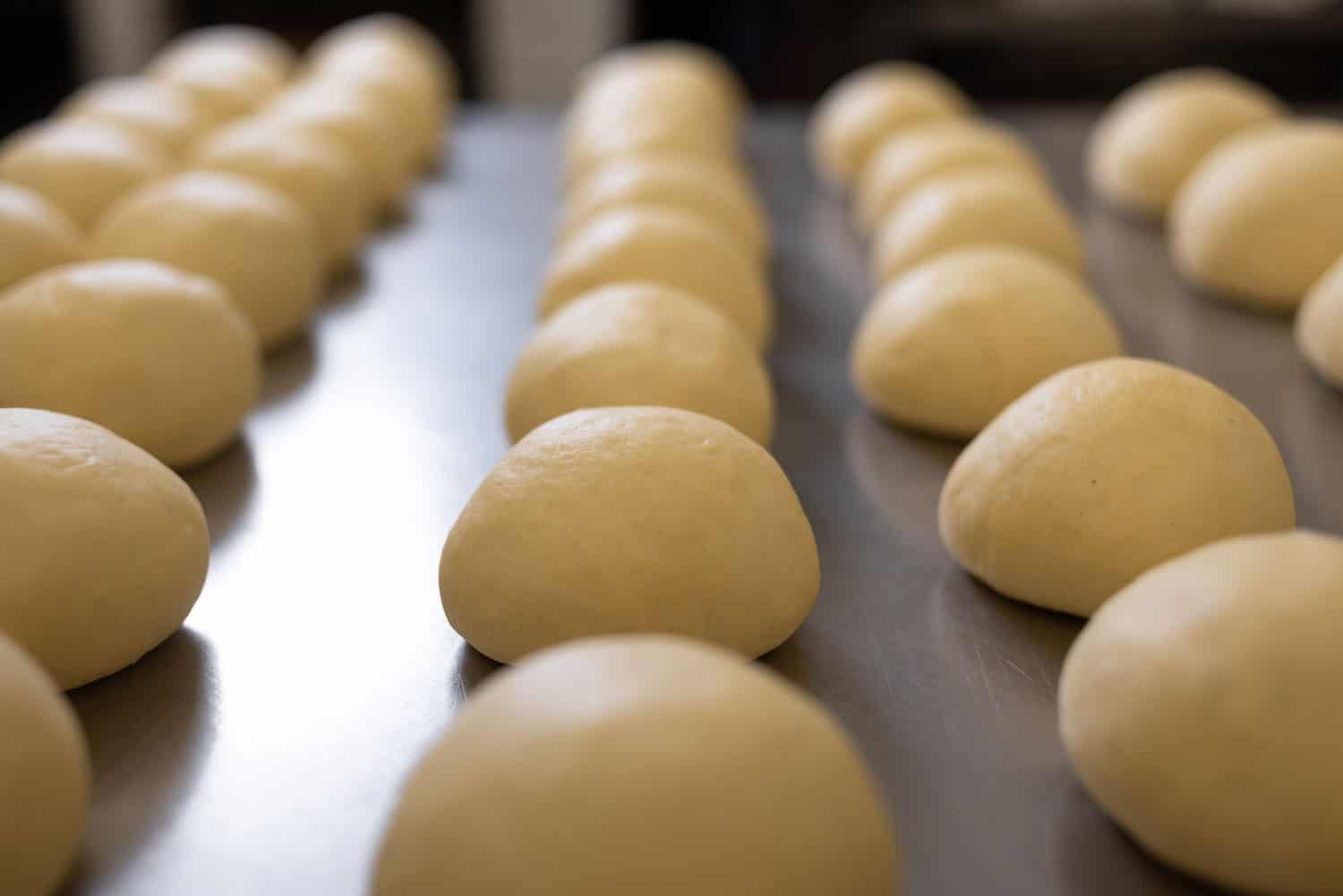 自制白披萨面团,的圆面包或烘焙食品金属切削。