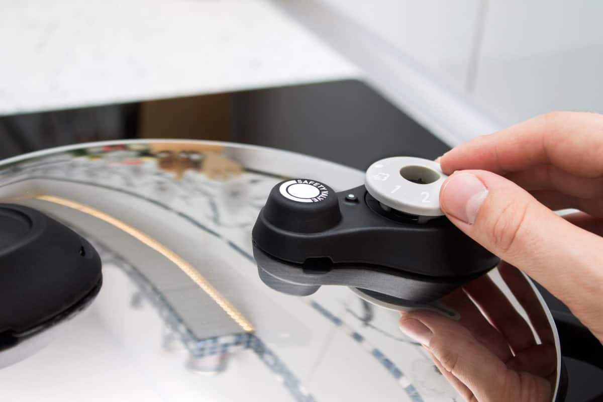 Woman taking off the cover of the pressure cooker