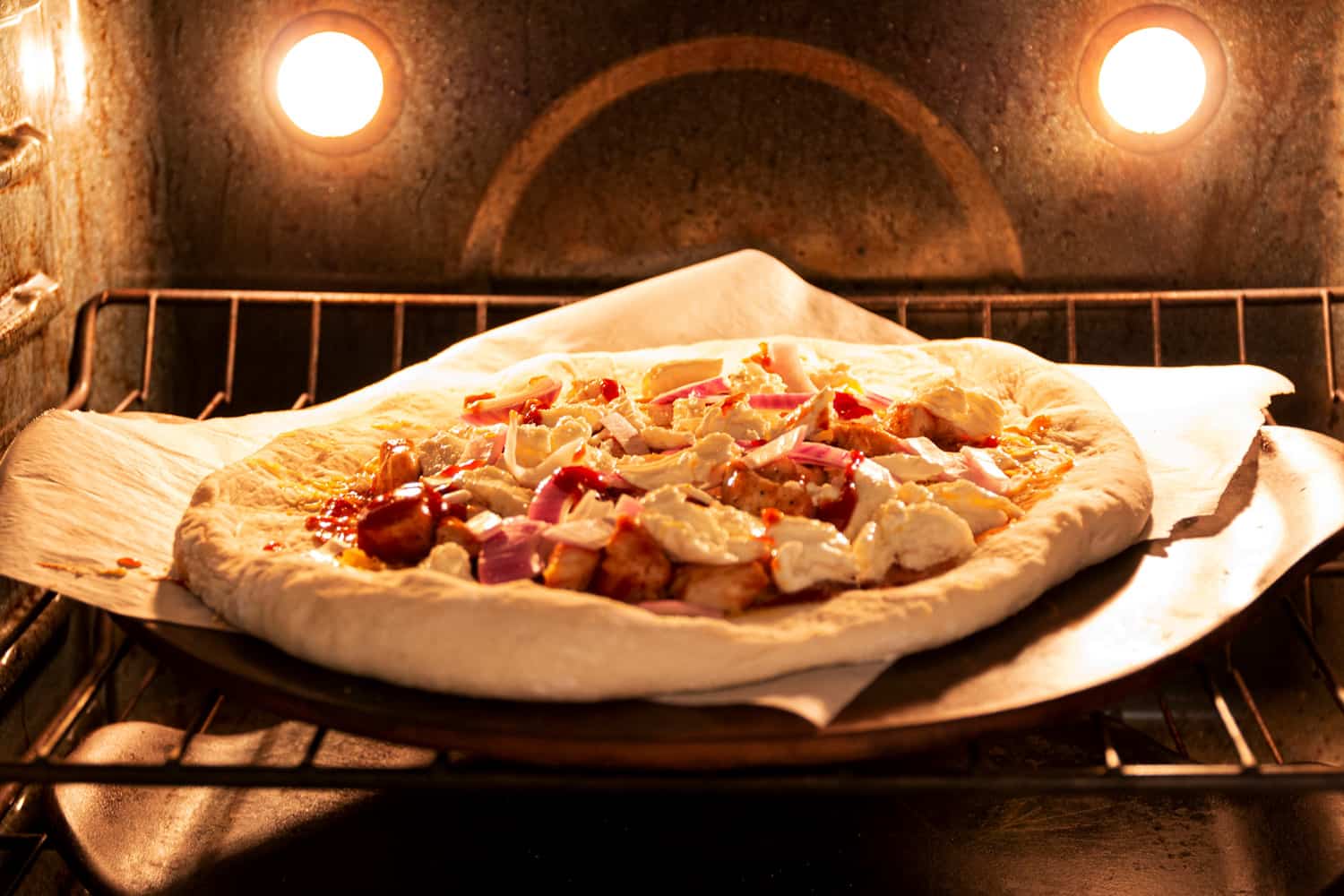 自制烧烤鸡肉披萨在烤箱烹饪石头烹饪。