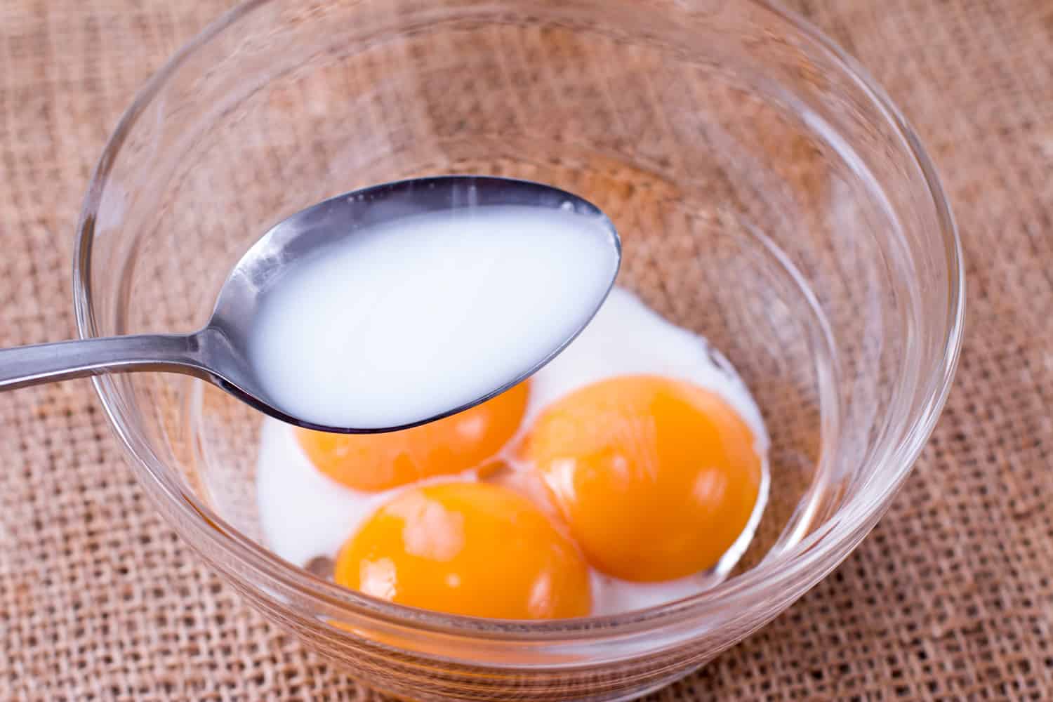 添加牛奶在玻璃碗蛋黄
