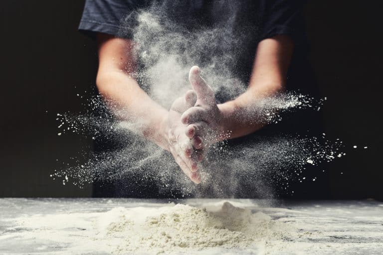 Clap hands of baker with flour in restaurant kitchen - Can You Use Pizza Flour To Bake Bread