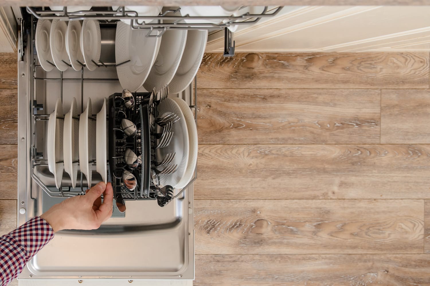 在老式的木制厨房里，在打开的洗碗机和干净的盘子里，Close up man hand hold plate雷电竞官网网址
