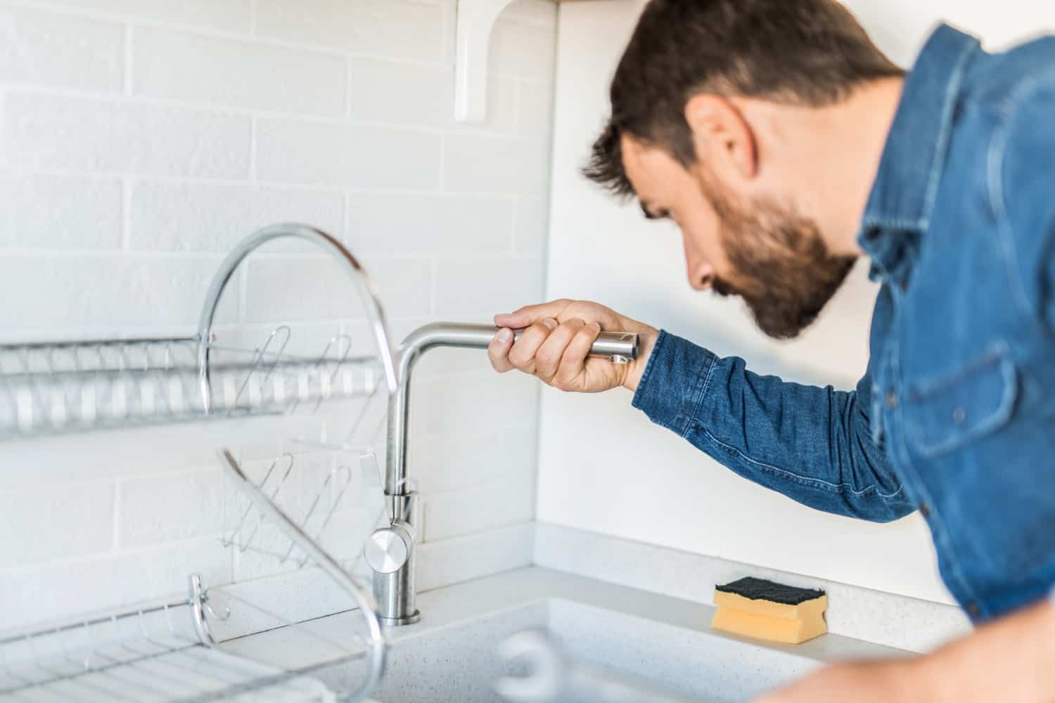 特写的水管工修理漏水的水龙头在厨房里。雷电竞官网网址