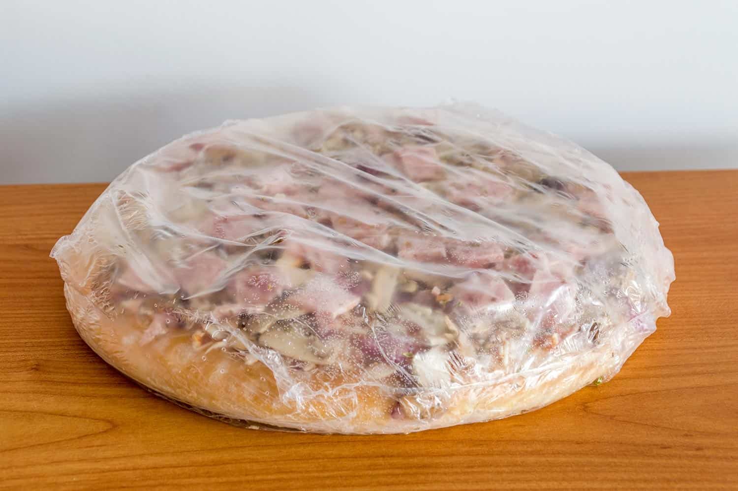 冷冻披萨在箔火腿和蘑菇”width=