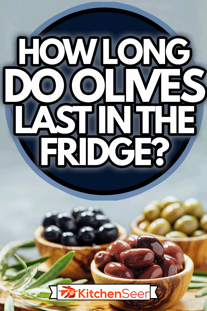 不同类型的橄榄放在橄榄木碗里，橄榄油放在木砧板上，新鲜的橄榄叶上，橄榄在冰箱里能放多久?