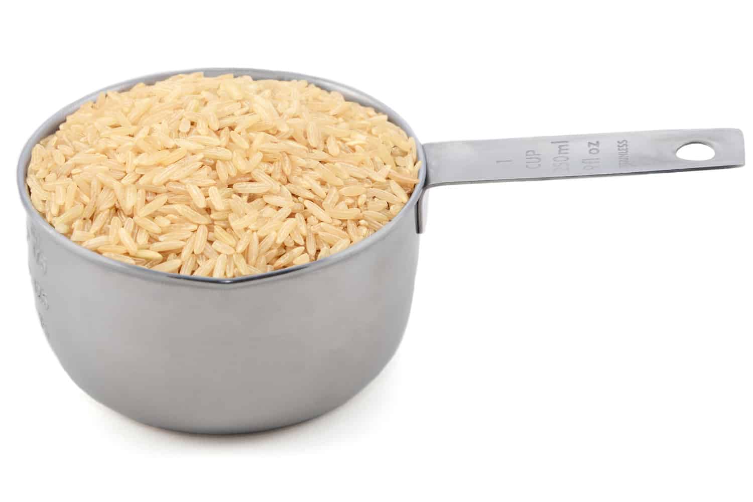 美式量杯中的长粒糙米，孤立在白色背景上