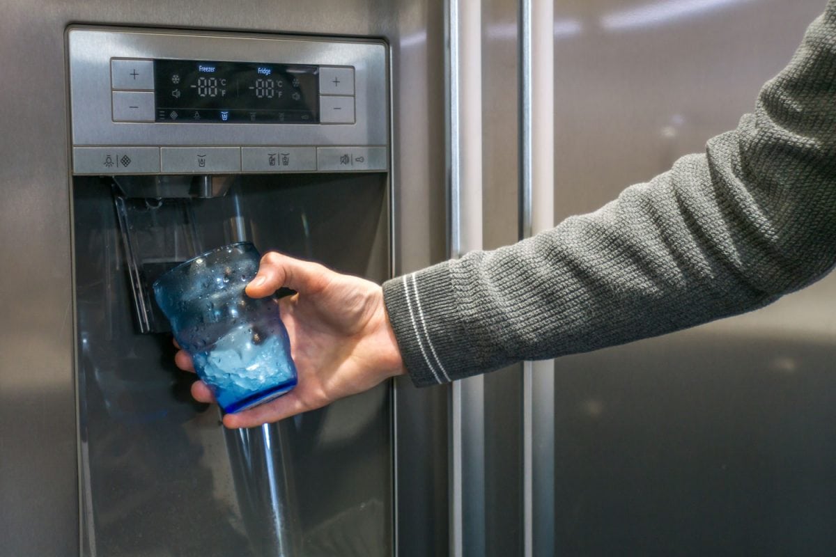 男人把水从冰箱的自动售货机