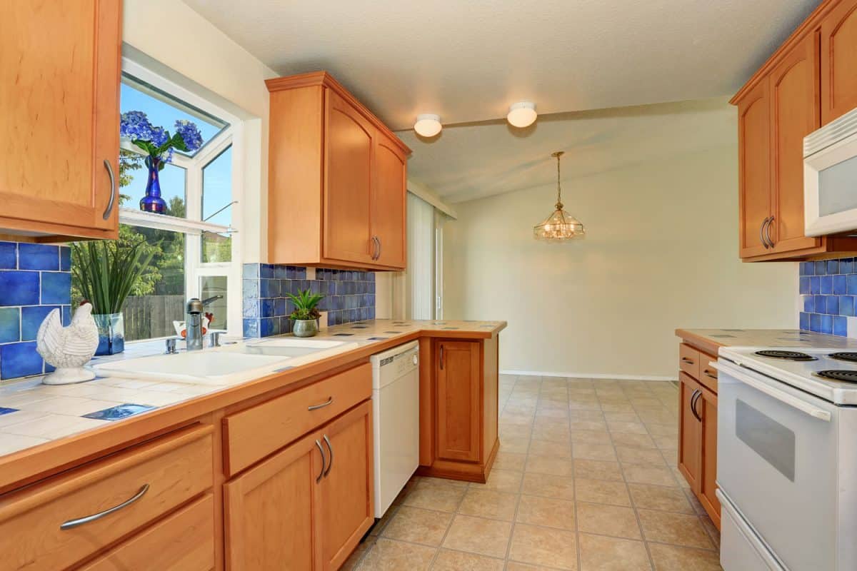 橡树厨柜雷电竞官网网址搭配白色的台面在一个狭窄的厨房