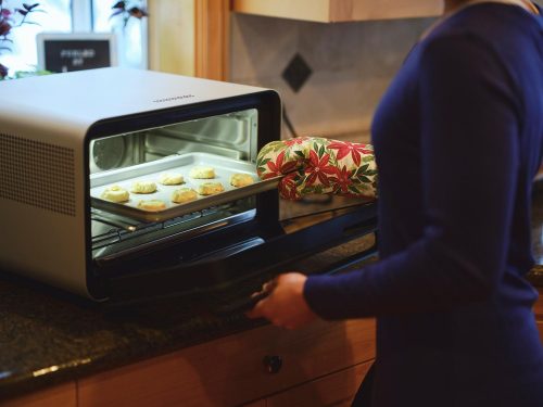 一个女人在厨房里用烤箱雷电竞官网网址