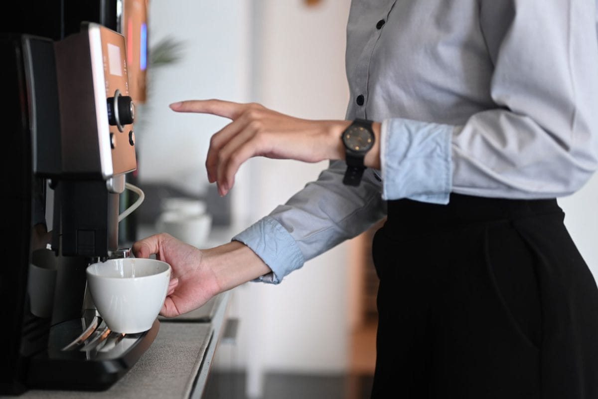 一个女商人在咖啡机里倒咖啡