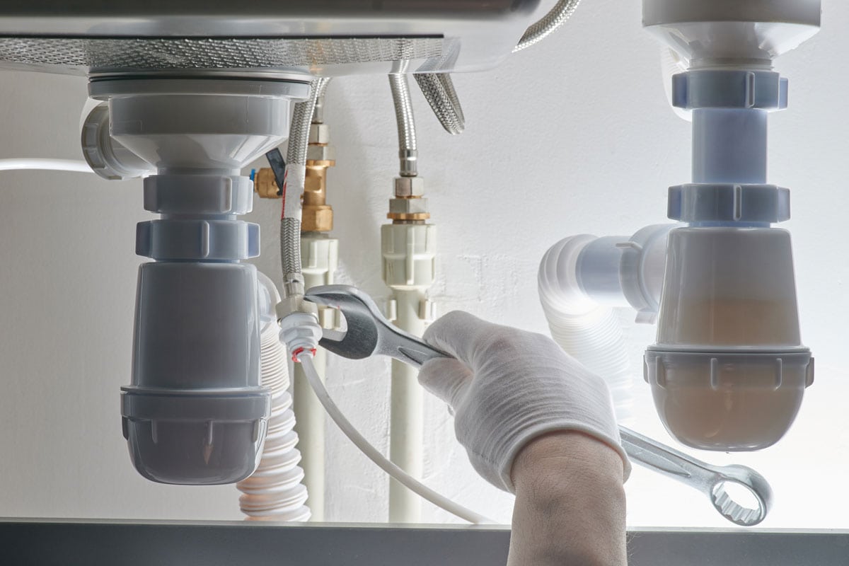 用扳手拧紧管道上的螺丝