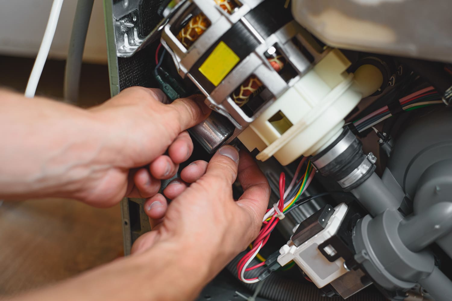 男性手修理坏了的洗碗机