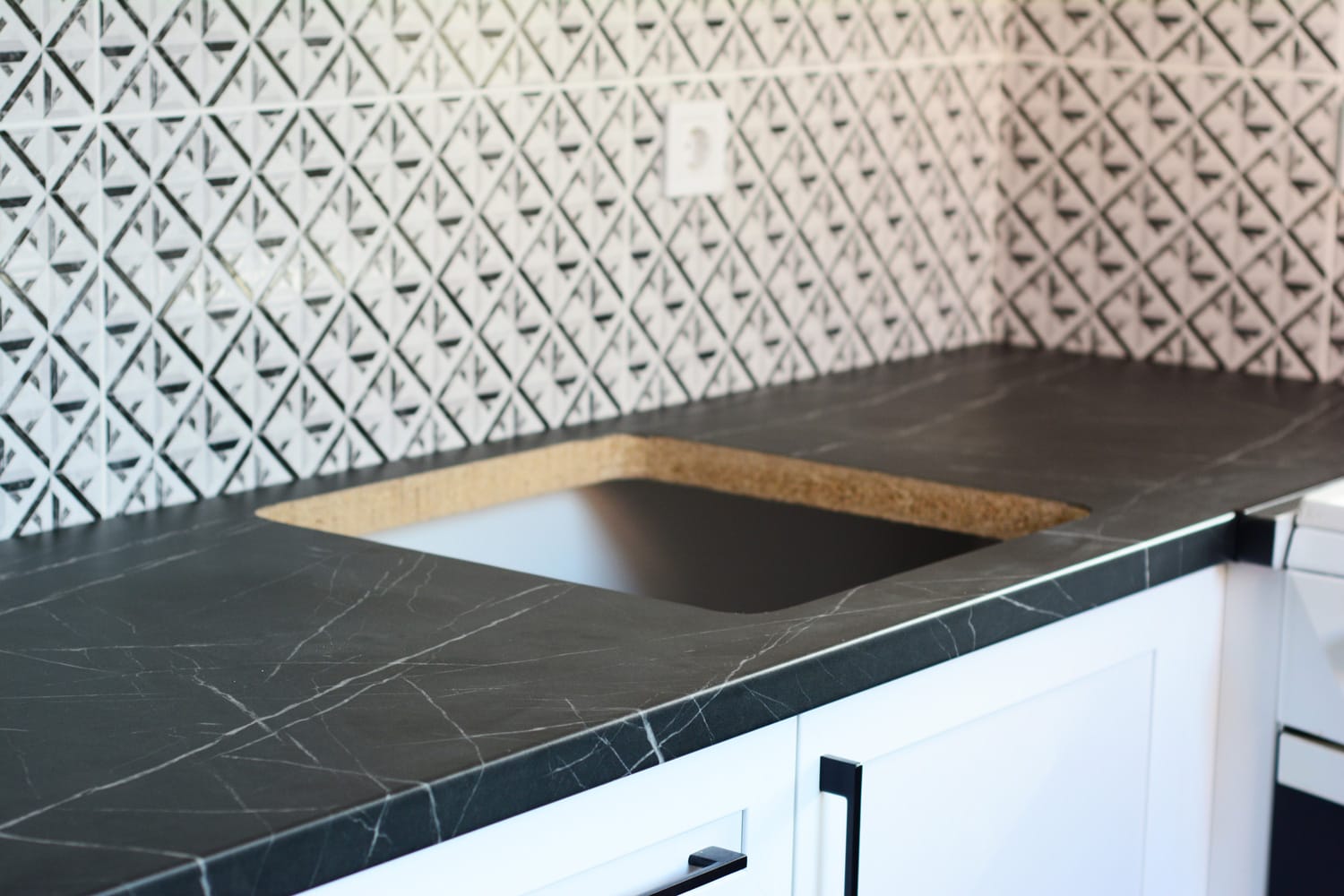 新厨房家雷电竞官网网址具安装瓷砖的特写厨房连壁与电源插座和厨房工作台削减沉孔。