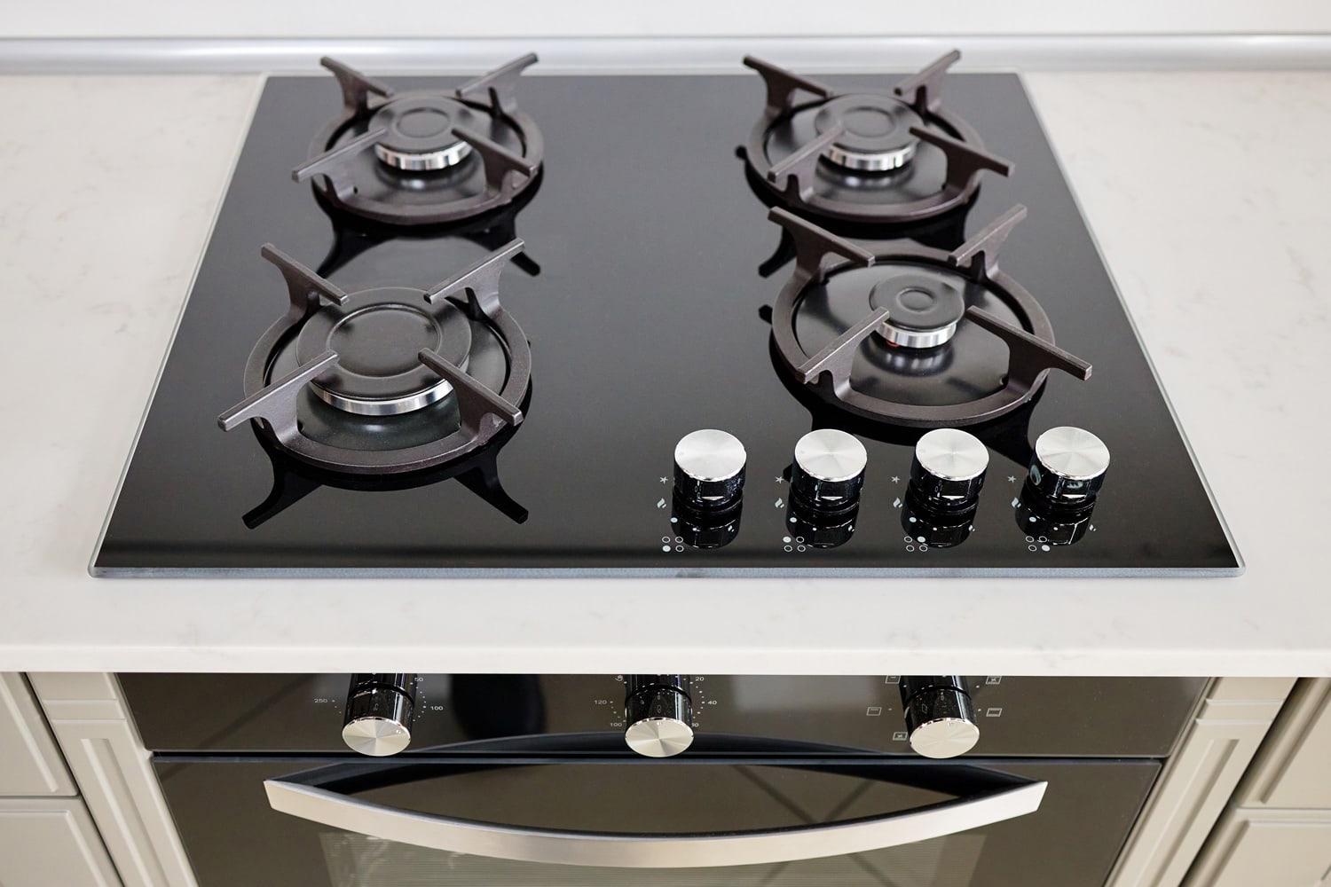 现代内置烤箱和煤气炉经典设计在浅色石材大理石或花岗岩台面下，在当代厨房的内部。雷电竞官网网址