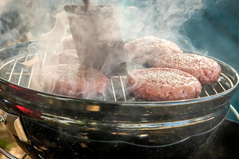 一名男子在木炭烧烤上烹饪牛肉和火鸡肉饼，火鸡煮熟时应该是什么颜色?