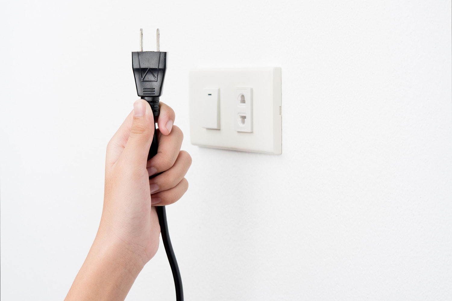 塞手或插头,插座上白墙背景,电击”width=