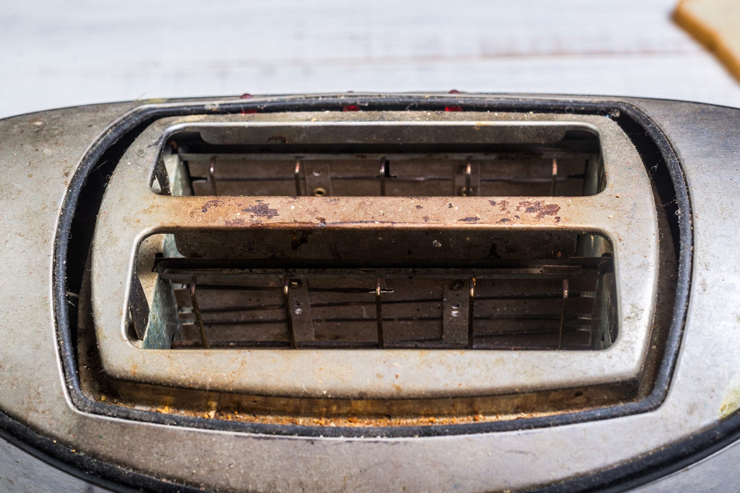 又脏又旧的烤面包机，白色木制背景。厨房电器坏了。雷电竞官网网址