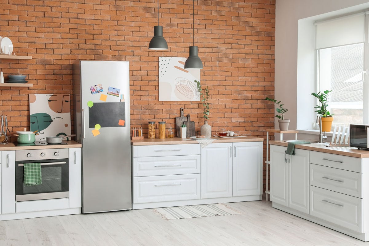 华丽的经典乡村风格的厨房，砖墙和悬挂的灯雷电竞官网网址