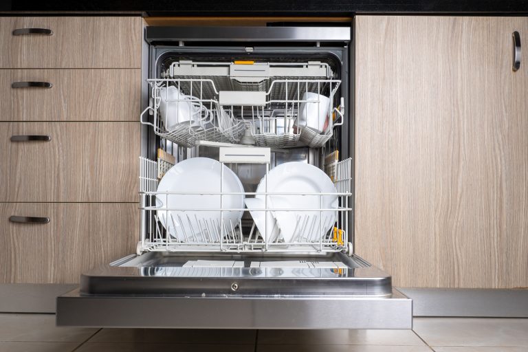 Open door of built-in dishwasher. Kitchen with integrated appliances. Plates and dishes in the dishwasher - How Long Does a Kenmore Dishwasher Run