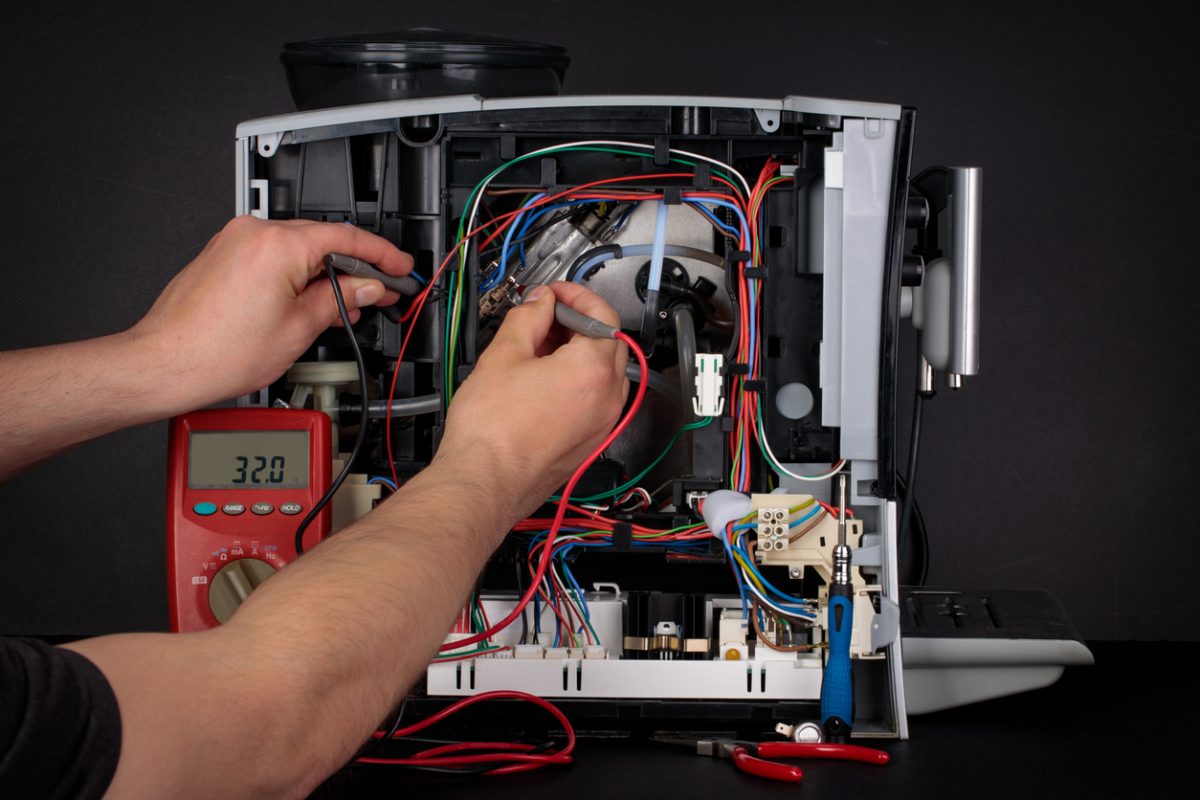 一个人修理损坏的咖啡机。在咖啡机里面。服务中心。