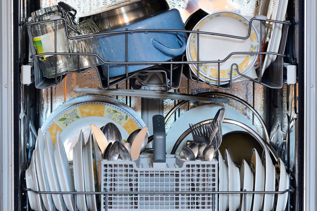 洗碗机装满了厨具、玻璃、盘子和器皿