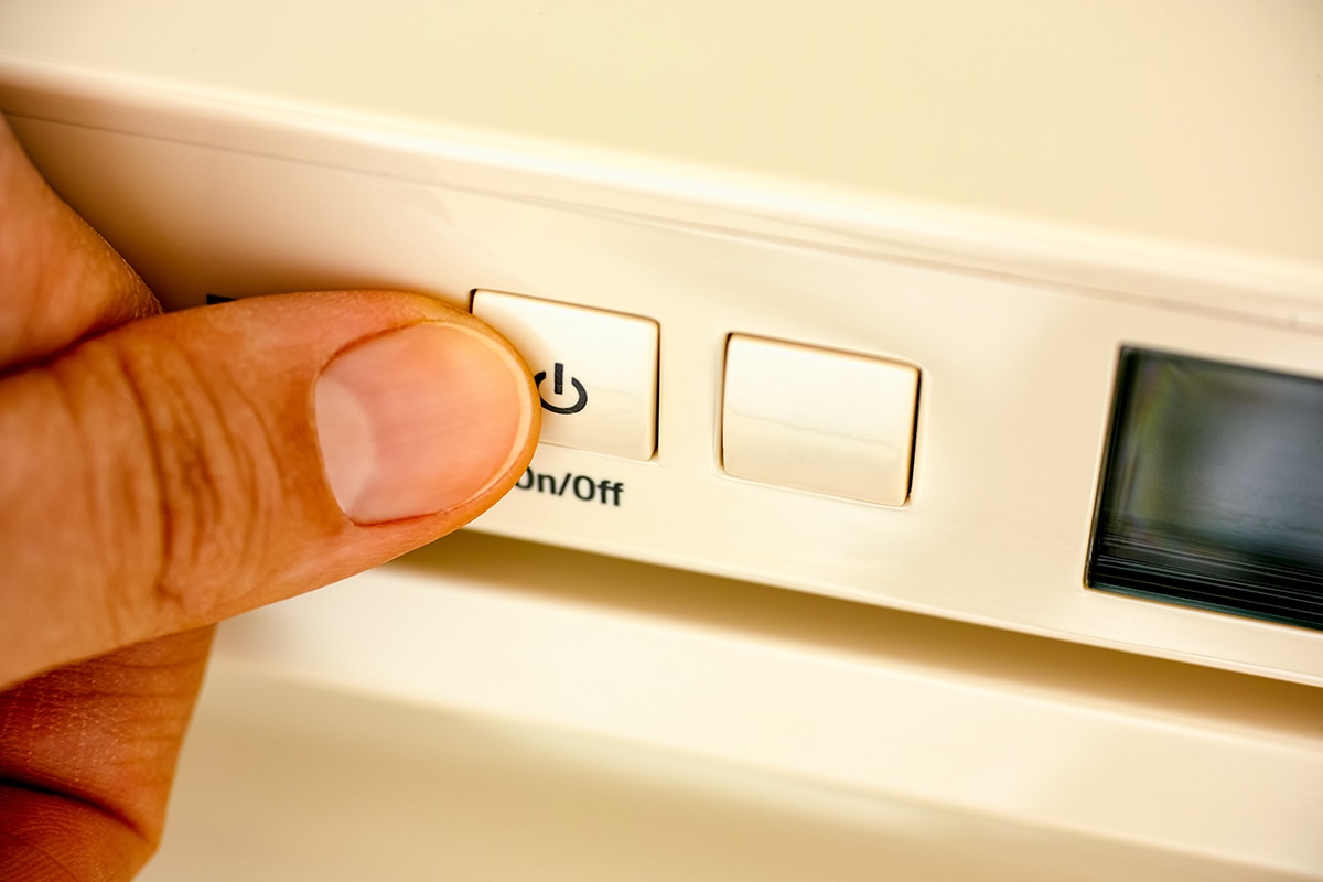 手指按下冰箱上的开关按钮