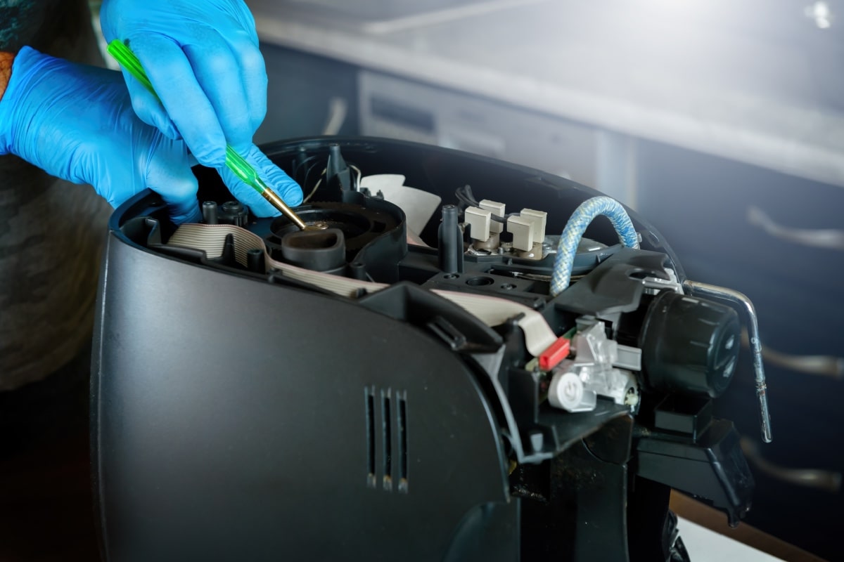 疏通针头-一个修理工修理坏掉的咖啡机，修理家用电器