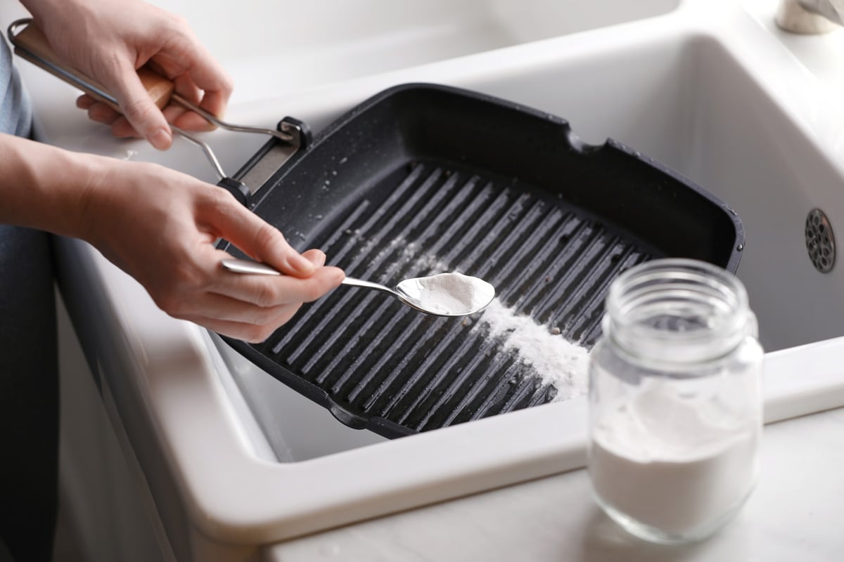 Woman pouring baking powder onto the skillet