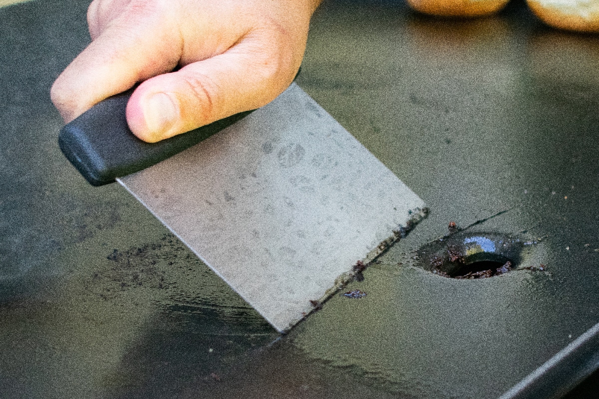 A person cleaning a griddle