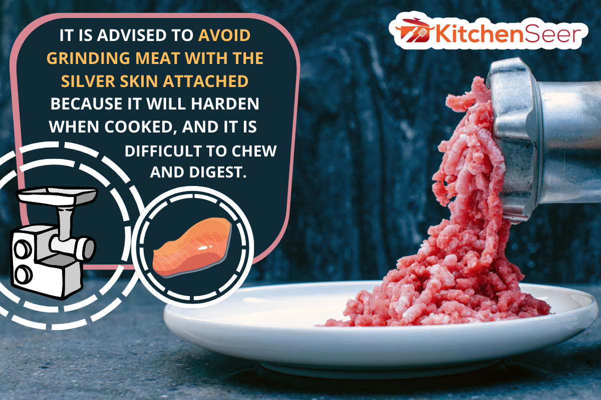 研磨金属手动绞肉机新鲜的红肉,特写与复制砖墙背景空间。——我能跟银色部分磨肉?