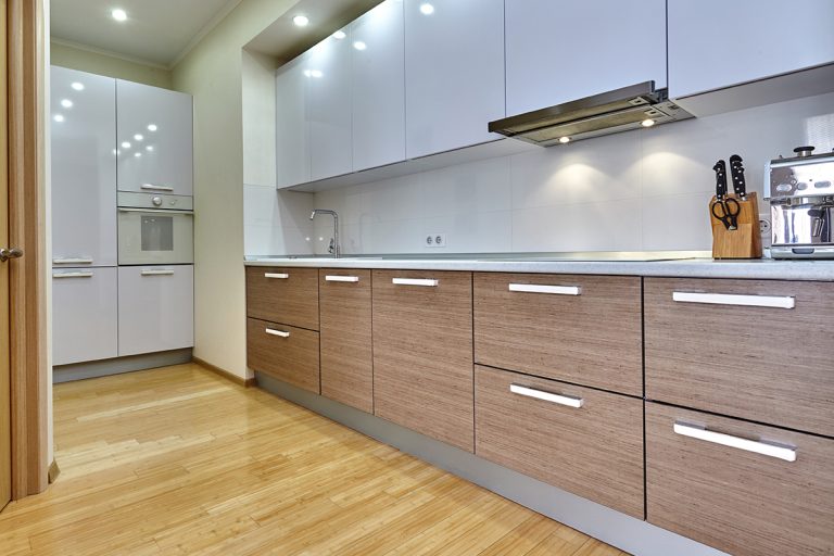 A kitchen with appliances and a beautiful interior, Thermofoil Cabinets: Pros & Cons [Considerations For Homeowners]