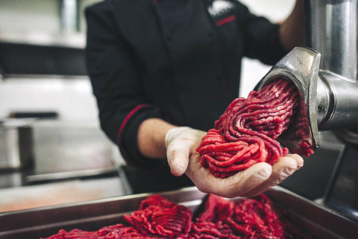男厨师屠夫做新鲜的牛肉绞肉机