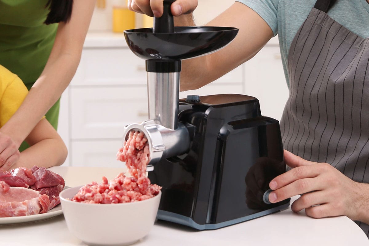 一个男人和他的家人一边用现代绞肉机准备晚餐