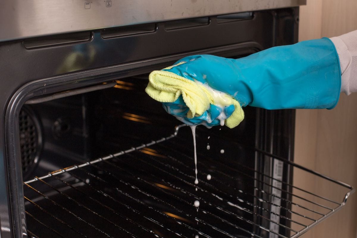 关闭防护手套的手挤在烤箱擦拭和清洗线