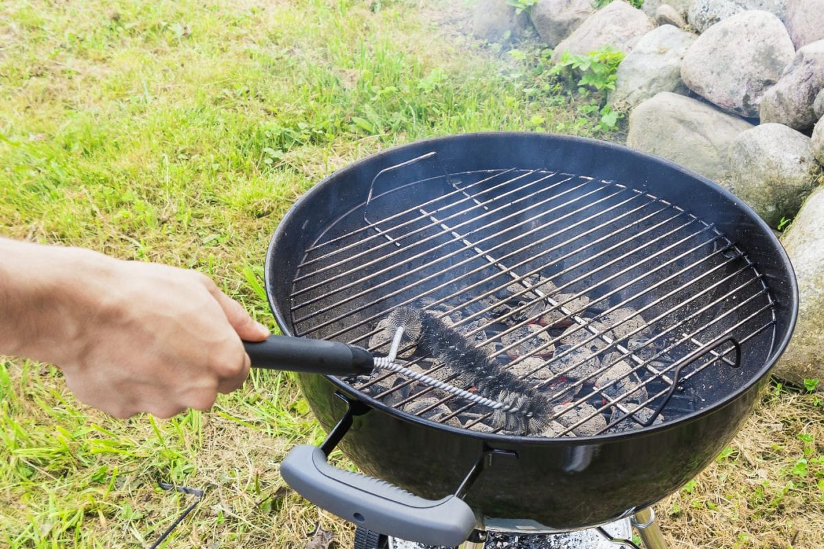 男手清洁硬刷轮烤架之前做饭