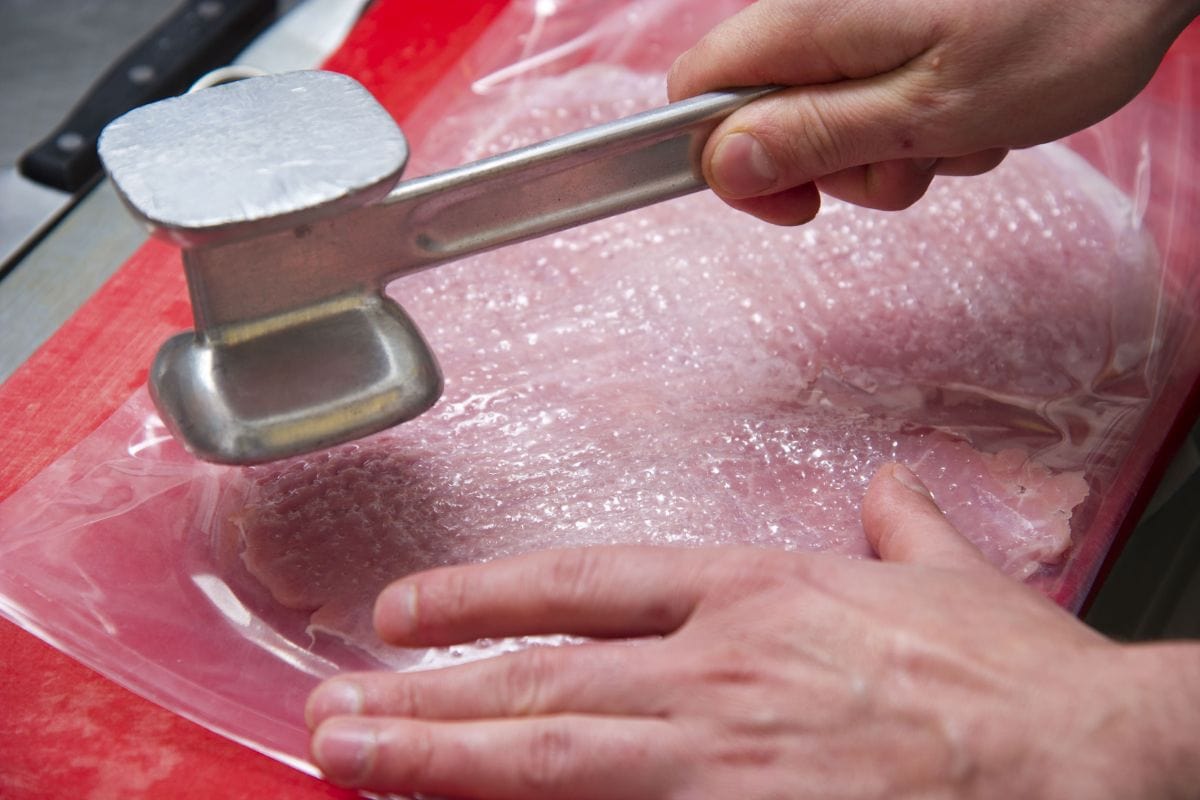 活肉锤,准备维纳炸肉排(小牛肉片)在一个厨房雷电竞官网网址