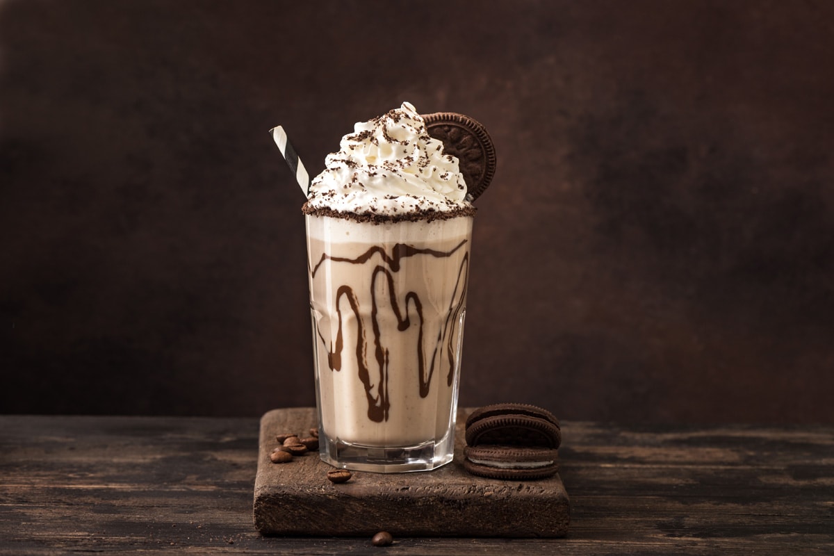 A delicious chocolate milkshake placed on a wooden coaster in the kitchen