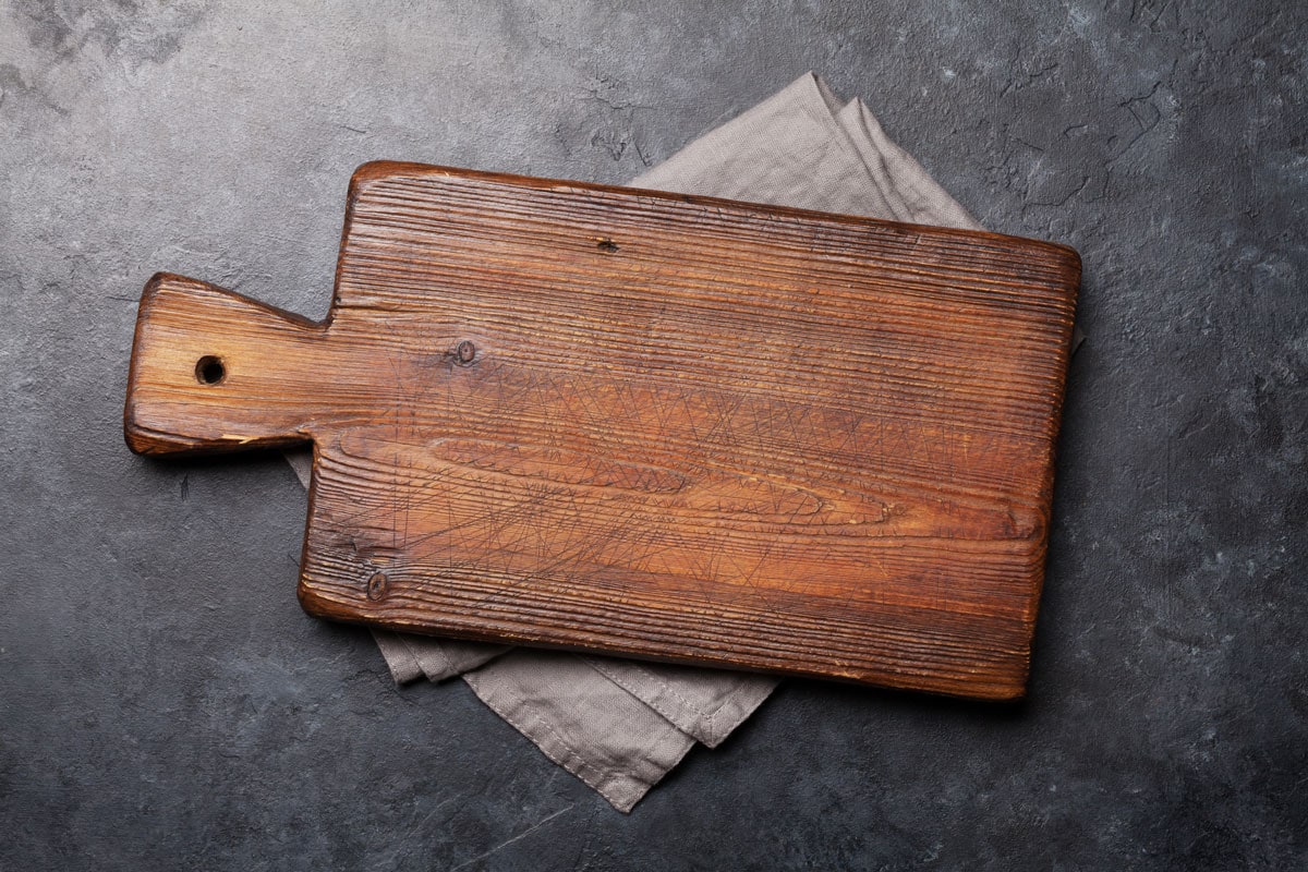 Old cutting board over towel on stone kitchen table. Top view flat lay, Why Is My Wooden Cutting Board Splintering?