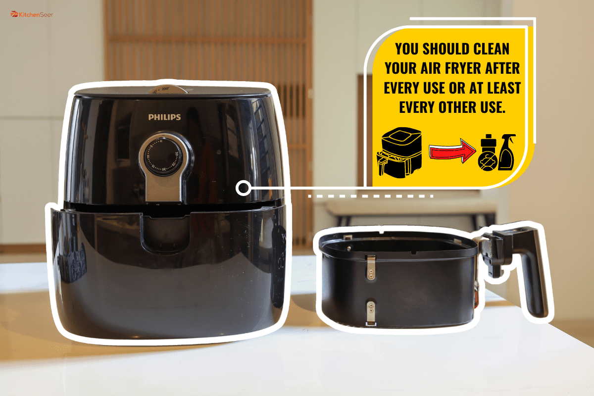 一个电动空气炸锅在桌子上模糊的厨房背景。雷电竞官网网址烹饪新常态的生活方式。多久清洗一次空气炸锅?每次用完都要洗吗?]