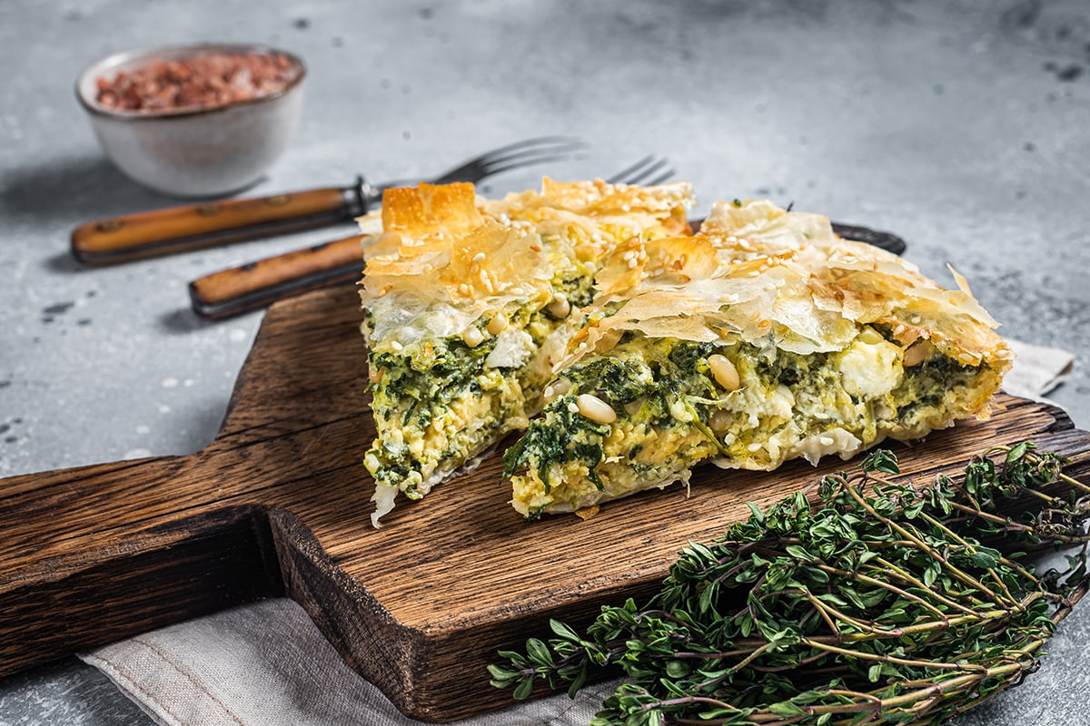 希腊派加菠菜和奶酪，放在木板上