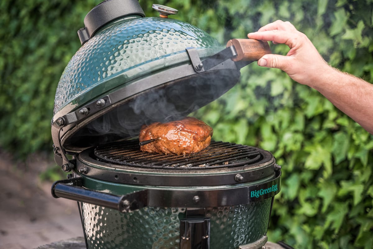 2022年9月15日:手打开大绿蛋混蛋kamado烧烤着一块肉。