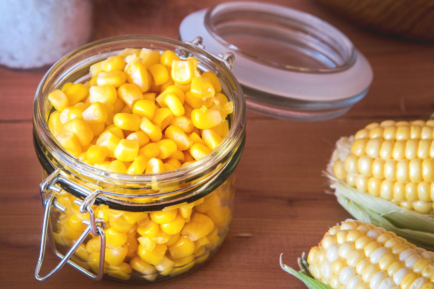 Homemade marinated corn in a glass jar.