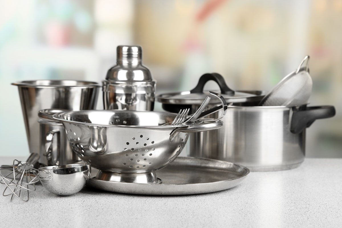 Stainless steel kitchenware on table, on light