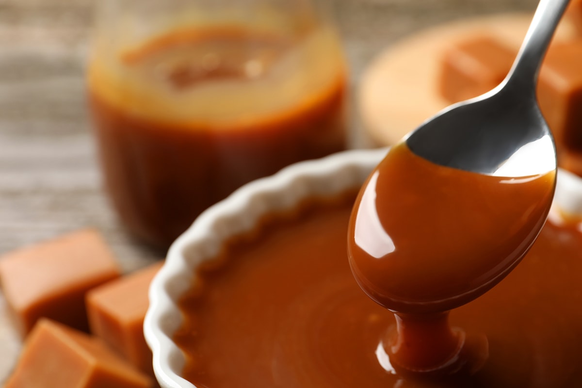 用勺子从桌上的碗里拿奶油糖果