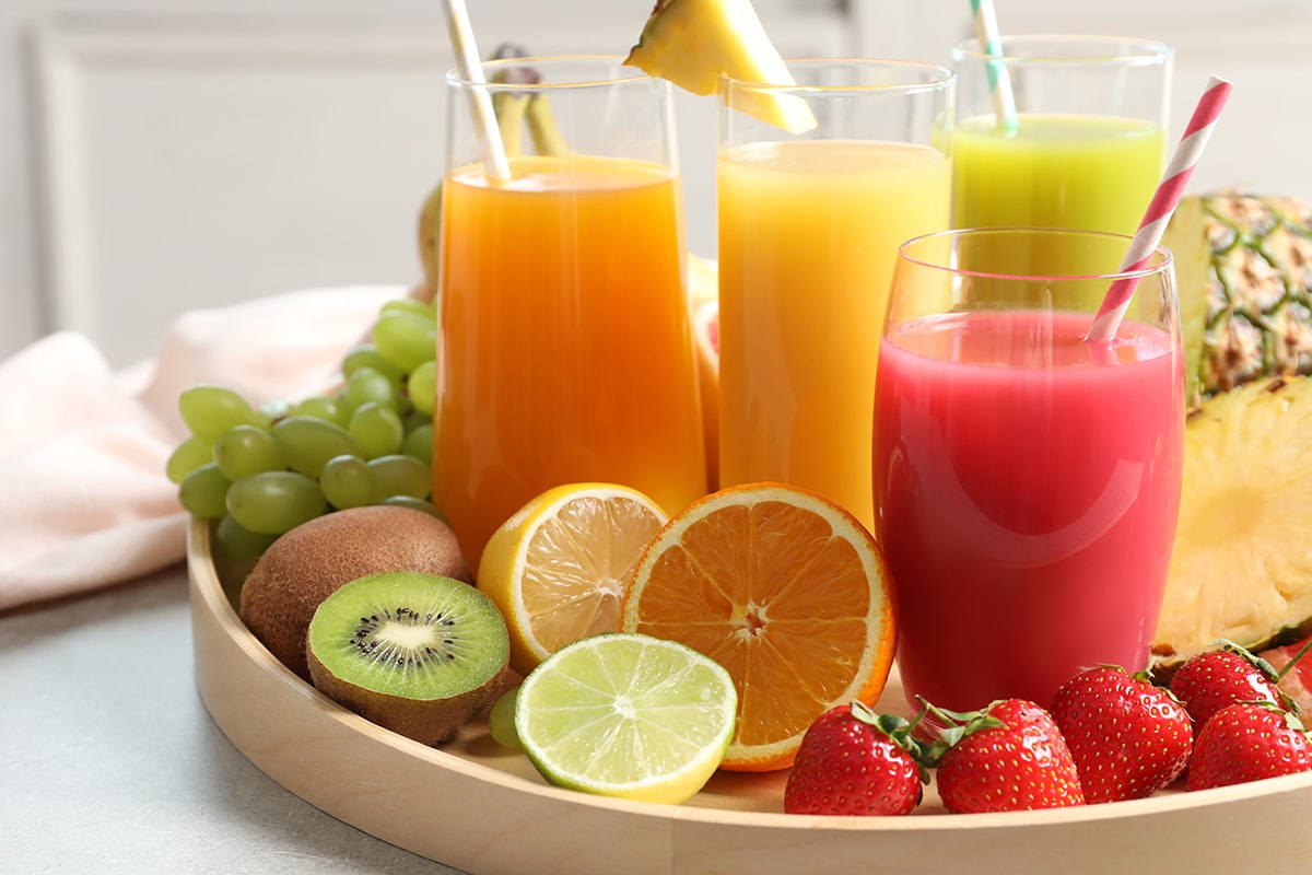木托盘上有不同果汁和新鲜水果的玻璃杯
